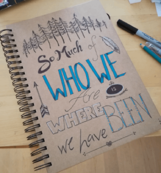 hand lettered journal cover with text - so much of who we are is where we have been